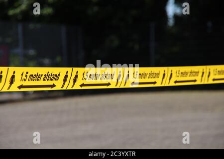 Gelbes Plastikband mit 1,5 Meter Abstand in niederländischer Sprache, um Menschen wegen der Corona covid-19-Krise in der Ferne zu halten Stockfoto