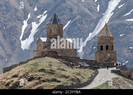 14. Jahrhundert Sameba (Trinity) Kirche in Gergeti + schneebedeckten Kaukasus-Berge, Georgien Stockfoto