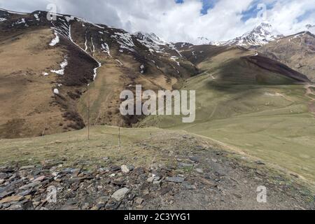 Schneebedeckte Kaukasus-Berge, gegenüber 14. Jahrhundert, Tsminda Sameba aka Gergeti Trinity Church Georgia Stockfoto