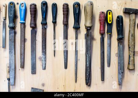 Satz von Tischlerwerkzeugen. Eine Reihe von Raspeln in einem Regal für Holzgeräte. Schleifraspeln für Holz- oder Metallwerkstatt Stockfoto