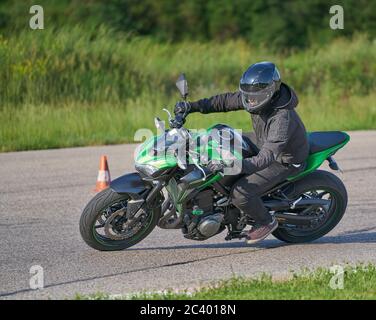 Motorradfahrer bei Sportfahrrad Fahrten durch leere Asphaltstraße. Sportfahrrad. Stockfoto