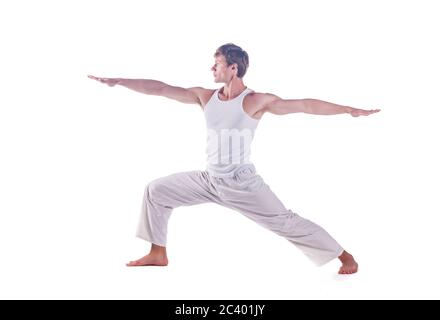 Mann, der Yoga praktiziert, indem er die Haltung des Kriegers 2 übt. Virabhadrasana 2, Stockfoto