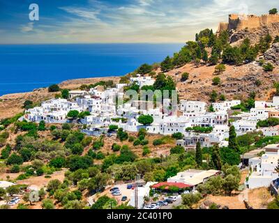 Das berühmte und historische mittelalterliche Dorf Lindos auf der griechischen Insel Rhodos mit der Akropolis im Hintergrund Stockfoto
