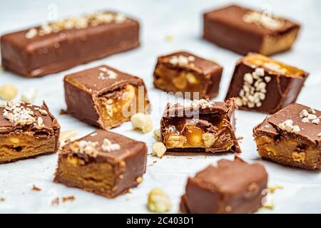 Rohe vegane Schokolade mit Karamellstreifen, weißer Hintergrund. Gesundes Dessertkonzept. Stockfoto