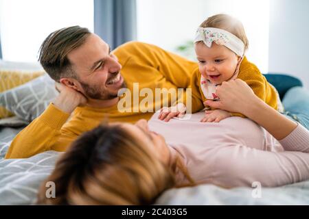 Eltern genießen das Spielen mit Baby Mädchen zu Hause Stockfoto
