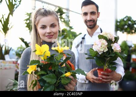 Besitzer von Blumenladen halten schöne blühende Zimmerpflanzen Stockfoto