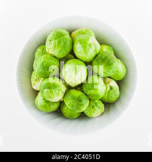 Overhead shot Rosenkohl in einem keramischen Schüssel gelegt. Auf weiß Isoliert Stockfoto