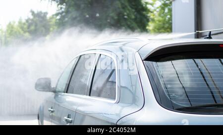 Wasser spritzt unter Druck. Waschen Sie das Auto bei Selbstbedienung. Heckscheibe. Autowaschservice im Freien Stockfoto