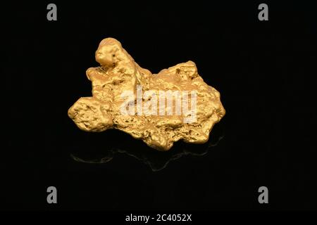 Großes Goldnugget auf schwarzem Spiegelhintergrund. Hochauflösendes Foto. Volle Schärfentiefe. Stockfoto