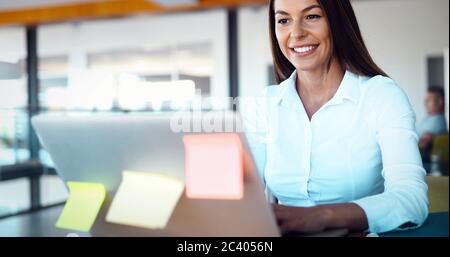 Junge Mitarbeiter arbeiten am Computer während der Arbeitszeit im Büro Stockfoto