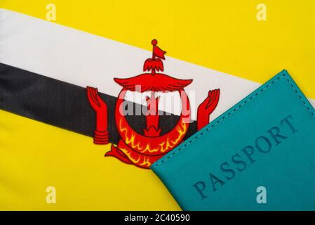 Auf dem Hintergrund der Flagge von Brunei Darussalam ist ein Reisepass. Das Konzept von Reisen und Tourismus. Stockfoto