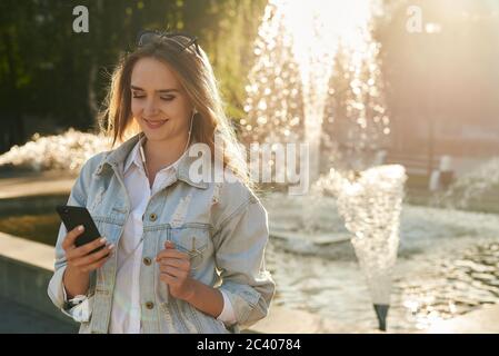 Das Mädchen in Kopfhörern. Das Mädchen bekommt eine Botschaft der Plessure. Das Mädchen hört eine gute Voicemail. Stockfoto