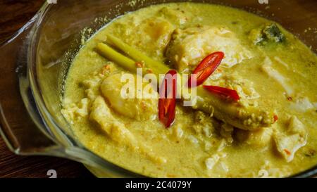 Telur Masak Lemak Cili PADI oder Ei in Kokosnusscreme mit Vogelperlchen in Englisch, ist eine würzige, reiche gelbe Kokosnusssoße, die mit Chili p gekocht wird Stockfoto