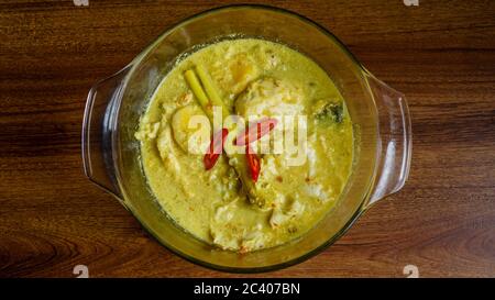 Telur Masak Lemak Cili PADI oder Ei in Kokosnusscreme mit Vogelperlchen in Englisch, ist eine würzige, reiche gelbe Kokosnusssoße, die mit Chili p gekocht wird Stockfoto