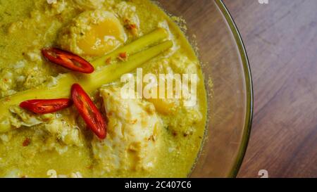 Telur Masak Lemak Cili PADI oder Ei in Kokosnusscreme mit Vogelperlchen in Englisch, ist eine würzige, reiche gelbe Kokosnusssoße, die mit Chili p gekocht wird Stockfoto