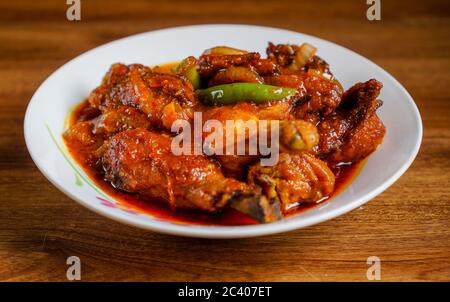 Ayam masak merah ist ein malaysisches traditionelles Gericht. Das bedeutet wörtlich Huhn "gekocht-rot" in Englisch. Es ist eine Auflaufform von Hühnerstücken in getrockneten c Stockfoto