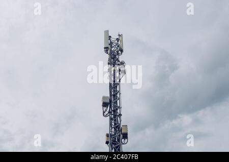 Telekommunikations-Repeater-Turm für die Mobilfunkindustrie, moderne Technik gegen bewölkten bewölkten Himmel Stockfoto