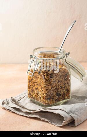 Gesundes Frühstück, Müsli, in einem hohen Glas auf einem rosa Hintergrund Stockfoto