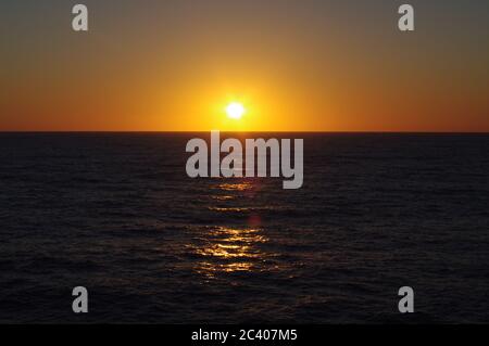 Sequenz von Bildern eines Sonnenuntergangs vom gleichen Standpunkt, Sequenz von Bildern des Sonnenuntergangs vom gleichen Standpunkt, Sonnenuntergang über dem Meer, Sonnenuntergang blauer Himmel über Dunkelheit Stockfoto