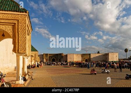 MEKNES, MAROKKO. 17. Okt. 2018. Handel auf dem Platz El Hedim und dem Tor Bab Mansour in Meknes, Marokko. Männer mit traditioneller Berber djellaba, Sonnenuntergang Stockfoto