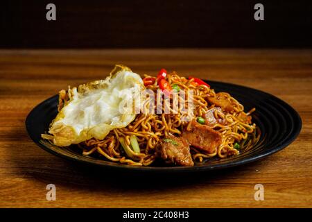 Dry Instant Noodle, malaysische maggi Goreng mamak oder würzige Dry Curry Instant Nudeln mit sonnigen Seite up Ei und Rindfleisch. Stockfoto