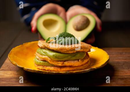 Low Carb Keto Diät Pfannkuchen aus Mandel Kokosmehl Stapel auf Teller mit Avocado Mousse auf Holztisch Hintergrund Nahaufnahme. Selektiver Fokus Stockfoto