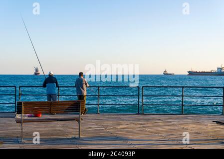 Die Fischer am Kai von Limassol Stadt mit Blick auf das Meer. Angeln auf der Insel Zypern. Stockfoto