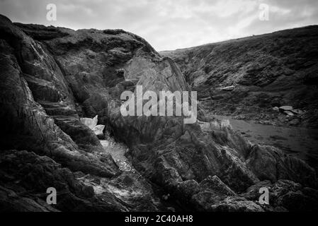 Burgh Island, Devon, Großbritannien. März 2016. Das Meer umrundt Felsen am Rande der Insel. Stockfoto