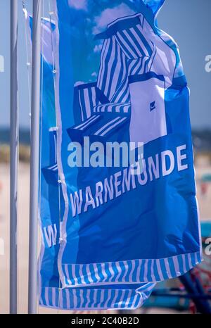 15. Juni 2020, Mecklenburg-Vorpommern, Warnemünde: Am Ostseestrand von Warnemünde wehen Fahnen mit der Aufschrift Warnemünde. Foto: Jens Büttner/dpa-Zentralbild/ZB Stockfoto
