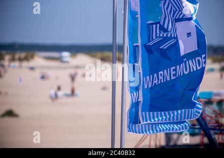 15. Juni 2020, Mecklenburg-Vorpommern, Warnemünde: Am Ostseestrand von Warnemünde wehen Fahnen mit der Aufschrift Warnemünde. Foto: Jens Büttner/dpa-Zentralbild/ZB Stockfoto