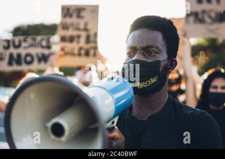 Menschen aus verschiedenen Kulturen und Rassen protestieren auf der Straße für Gleichberechtigung - Demonstranten tragen Gesichtsmasken während des Kampflagers für schwarze Menschenleben Stockfoto