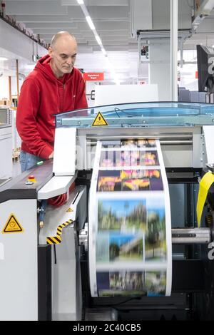 Oldenburg, Deutschland. Mai 2020. Ein Mitarbeiter des Fotodienstleisters CEWE steuert das Zuschneiden der gedruckten Fotos. Quelle: Sina Schuldt/dpa/Alamy Live News Stockfoto