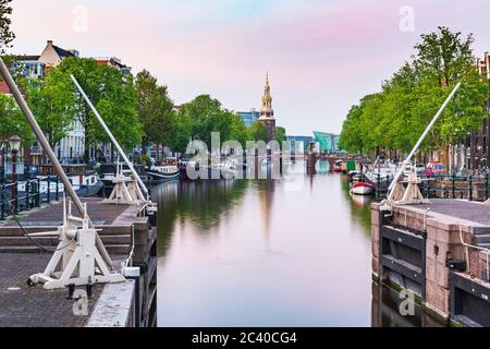 Amsterdamer Straßen und Kanäle in der Abenddämmerung, Sommersaison. Sint Antoniesluis, beliebtes Reiseziel für Touristen. Stockfoto