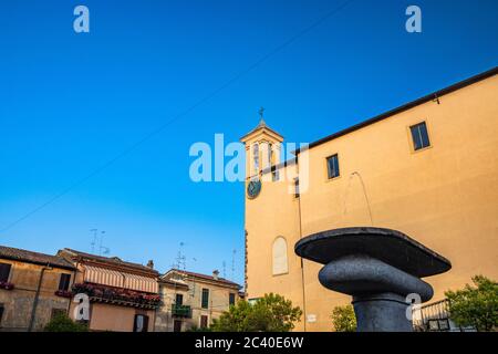 Das Kloster S. Maria delle Grazie, auf dem Santa Maria Platz. Der Glockenturm mit der Uhr. Der blaue Himmel bei Sonnenuntergang. Römischer Steinbrunnen im Vorgefürten Stockfoto