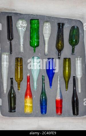 Farbige Flaschen unterschiedlicher Formen in der Wand eingebettet. Detail im Innenhof des Knust Hauses, Hundertwasser Museum. Stockfoto