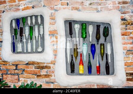 Ziegelwand mit farbigen Flaschen im Innenhof des Hundertwasser Museums, Kunst Haus Wien in Wien, Österreich. Stockfoto