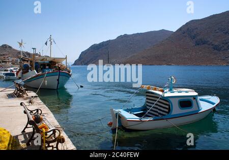 Kleine, traditionelle Fischerboote, die an einem hellen Sommertag in der Pedhi Bucht auf der schönen griechischen Insel Symi festgemacht sind Stockfoto