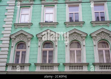 Vintage-Architektur, Wiener Wohnhausfassade. Renovierte Fassade eines alten Gebäudes mit charakteristischer Wiener Architektur. Nahaufnahme Stockfoto