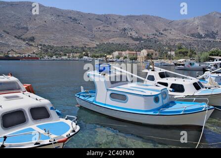 Kleine Fischerboote liegen im kleinen Hafen von Pedi auf der schönen griechischen Insel Symi. Stockfoto