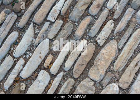 Mehrfarbige Steine auf dem Boden. Verschiedene Formen und Größen. Textur der Steinbeschichtung. Stockfoto