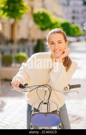 Glückliche junge Frau mit Fahrrad in der Stadt. Stockfoto