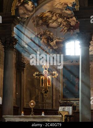 Die badia fiorentina (dante-Kirche) mit ihrem Presbitery und dem heiligen Kreuz, das von Sonnenstrahlen beleuchtet wird Stockfoto