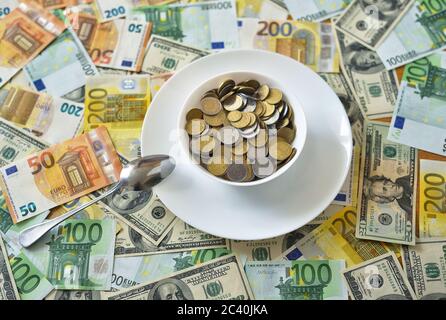 Teller mit Münzen. euro- und Dollarscheine auf dem Tisch Stockfoto
