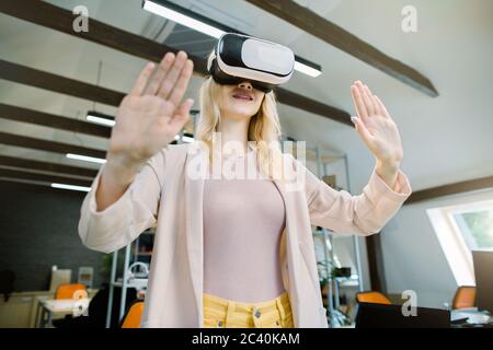 Virtual Reality 3d-Technologien. Junge kreative blonde Geschäftsfrau IT-Entwickler, Designer testen VR Virtual Reality Brille, gestikulieren, berühren Stockfoto