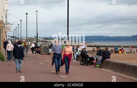 Portobello, Edinburgh, Schottland, Großbritannien. 23. Juni 2020. Ein ruhiger Strand, aber recht voll an der Promenade, die die Cafés beschäftigt hält, mit Temperaturen von 17 Grad Celsius und dicken Wolken mit gelegentlichen Nieselregen Duschen. Die Dinge werden sich in den nächsten Tagen mit Mini-Hitzewelle-Prognosen ändern. Stockfoto