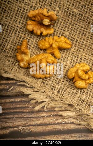 Geschälte Walnüsse in loser Schüttung auf einem Holztisch mit grober Struktur und Quaste. Gesunde Ernährung. Fitness-Diät. Nahaufnahme Stockfoto