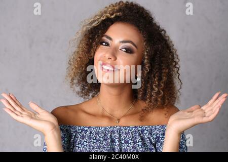 Attraktive junge Frau vor grauem Hintergrund Stockfoto