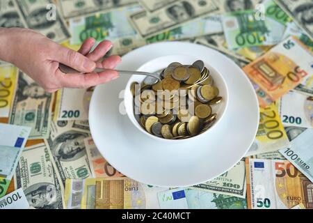Teller mit Münzen. euro- und Dollarscheine auf dem Tisch Stockfoto