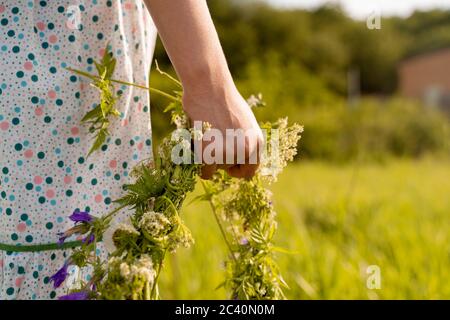 Hand Nahaufnahme mit einem Kranz von Blumen Stockfoto
