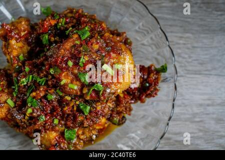 Saftiges Hühnerfleisch mit würziger und duftender Balado-Sauce. Balado-Paste wird aus Zutaten wie rotem Chili, Knoblauch und Schalotten hergestellt. Stockfoto